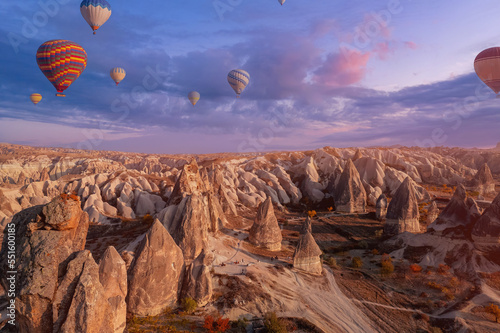 Beautiful sunset landscape group horse riding tour with hot air balloons in Cappadocia autumn Turkey valley from aerial view