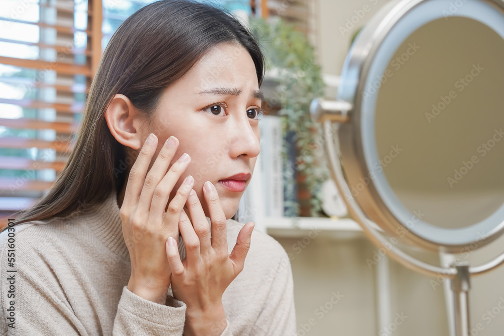 Dermatology, puberty asian young woman, girl looking into mirror