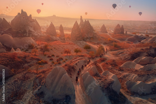 Beautiful landscape Cappadocia stone and old cave house with horse tour and hot air balloons in Goreme national park Turkey Sunset