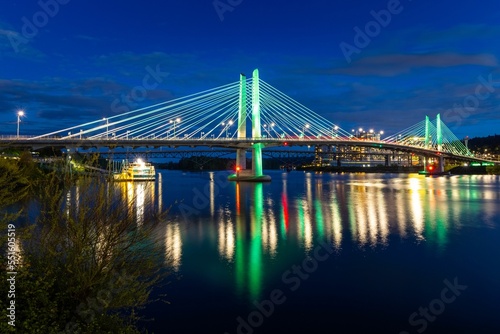 Lights of Tilikum Crossing Bridge reflecting on the water in the late evening photo