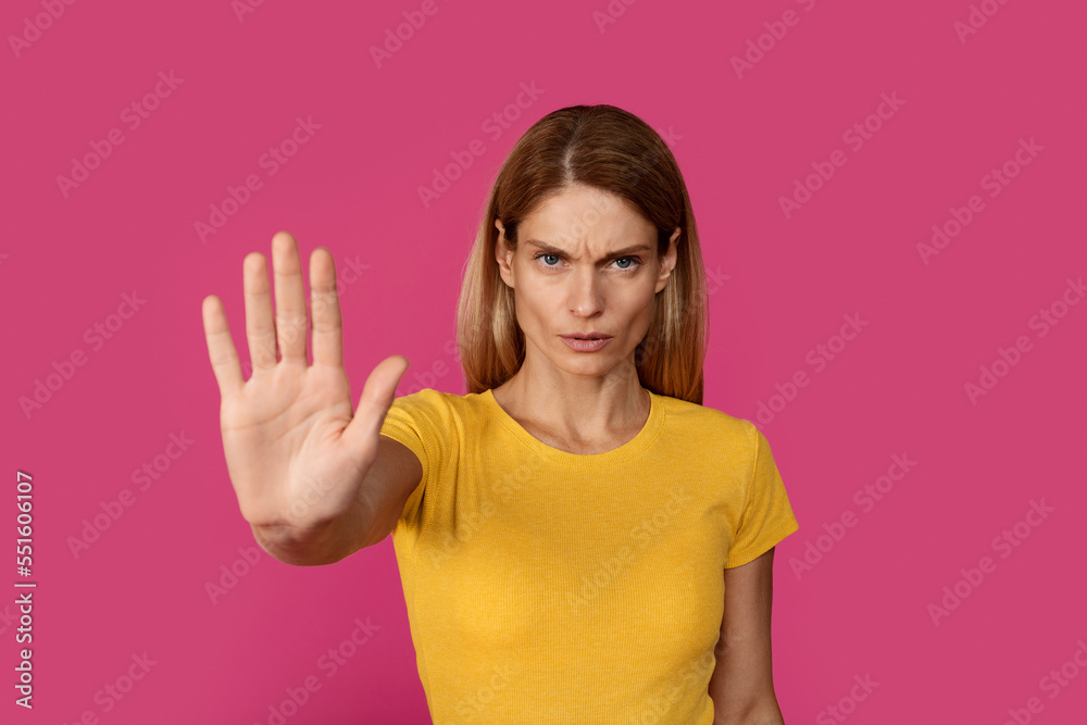 Serious sad confident adult caucasian woman blonde in yellow t-shirt shows palm hand Serious sad confident adult caucasian woman blonde in yellow t-shirt shows palm hand
