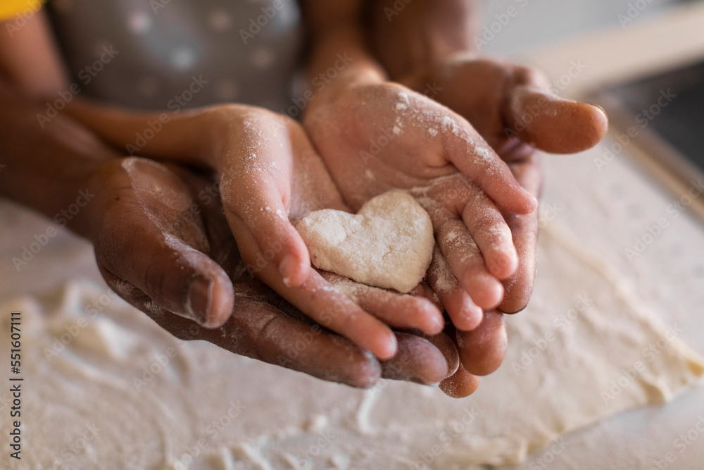 African American Father And Daughter Holding Heart Made Of Dough In Hands