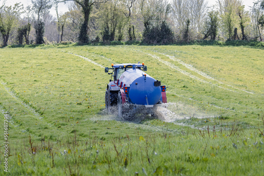 Fototapeta premium Farming blue lorry spraying the field