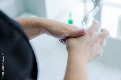 Women's hands are thoroughly washed with soap and water. Beautiful full hands underwater in the bathroom. Close-up of hands showing how to wash them properly. Proper hand washing. © Ольга Боровских