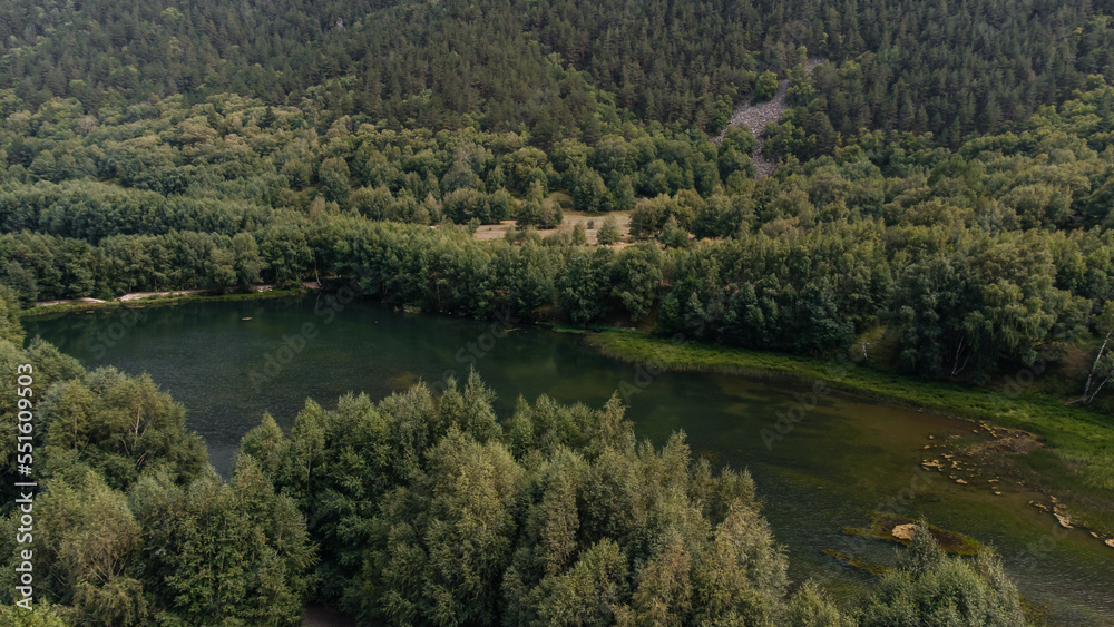 mountain lake of green shade surrounded by Christmas trees