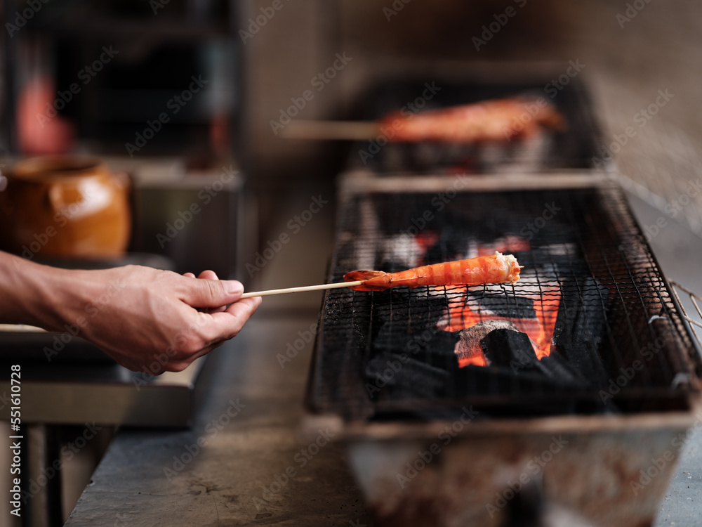 Street food vendor barbequing shrimp