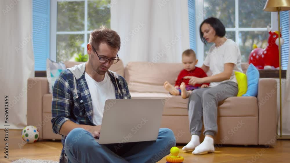 Mother sitting with baby while father is working on laptop. Realtime Mother sitting with baby while father is working on laptop. Realtime