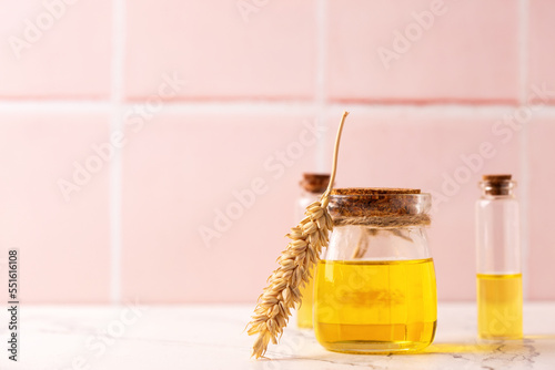 Natural skin care products. Bottles with organic wheat germ oil against pink tiled wall.   Beauty blogging, salon treatment concept. Selective focus. Place for text..