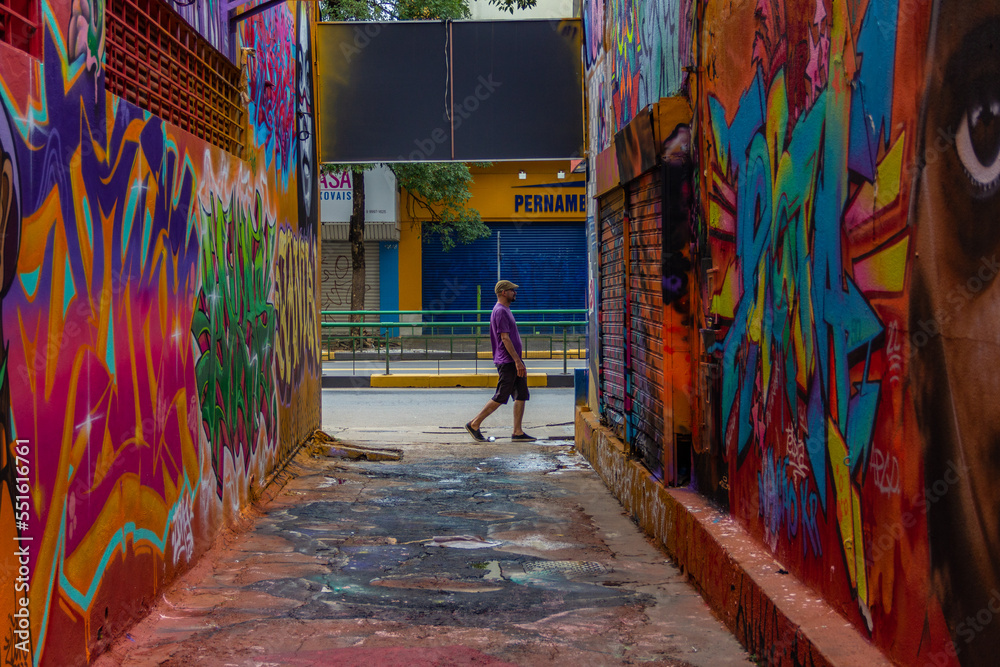 Um homem passando ao final do corredor do Beco da Codorna - um ponto turístico da cidade de Goiânia.
