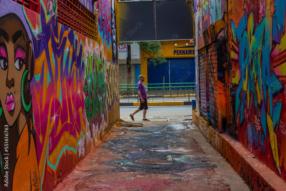 Um homem passando ao final do corredor do Beco da Codorna - um ponto turístico da cidade de Goiânia.