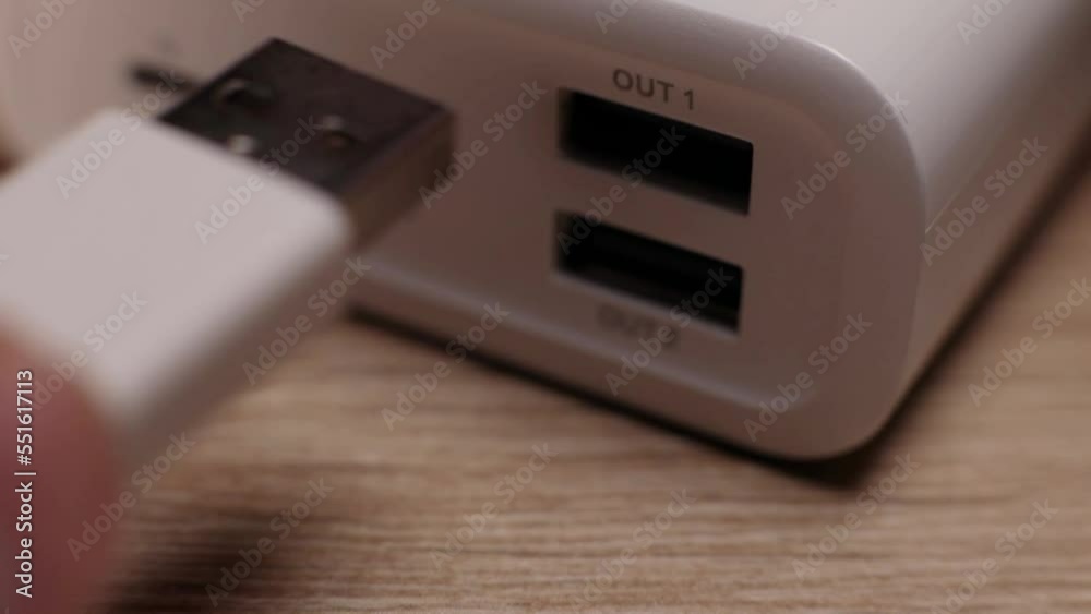 Hand puts connector into Power Bank battery charging close-up Hand puts connector into Power Bank battery charging close-up