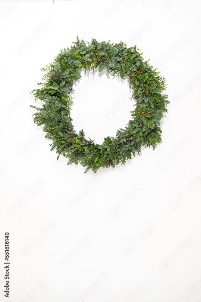 Christmas wreath of living branches of coniferous trees on a white background. DIY new year decor. Christmas wreath of living branches of coniferous trees on a white background. DIY new year decor.