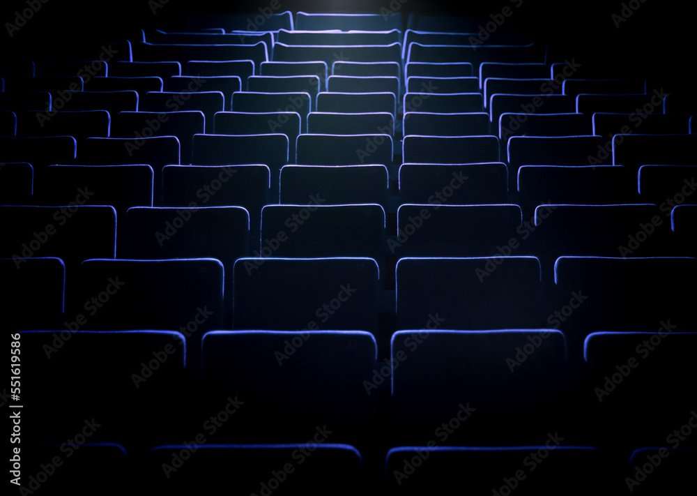 Empty movie theatre with blue light of the projector on the seats Empty movie theatre with blue light of the projector on the seats