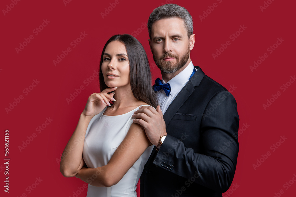 formal tuxedo couple of two isolated on red background. couple in formal tuxedo. studio shot formal tuxedo couple of two isolated on red background. couple in formal tuxedo. studio shot