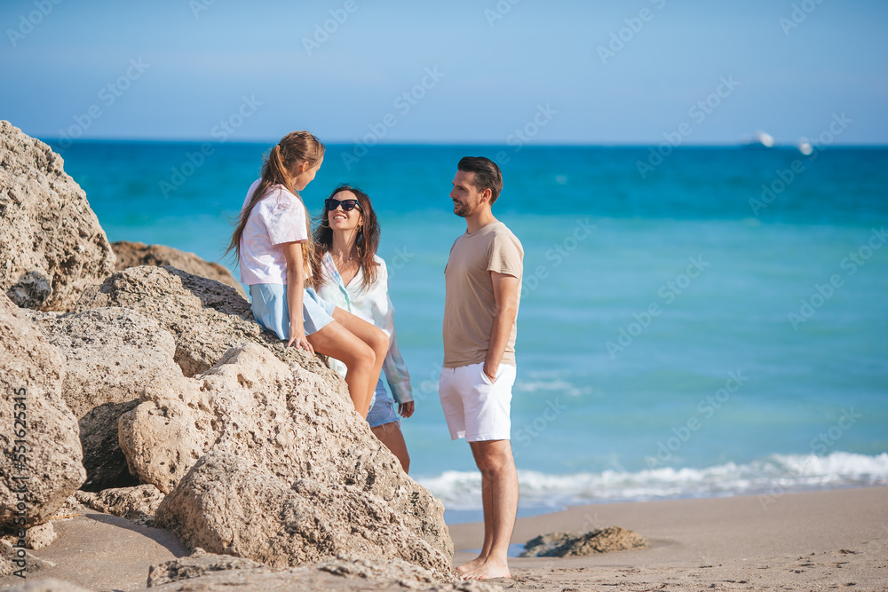 Young parents on the beach enjoy time with their daughter Young parents on the beach enjoy time with their daughter