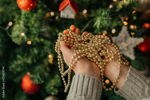 Close-up of a child's hands holding a Christmas tree garland. Holiday home decoration