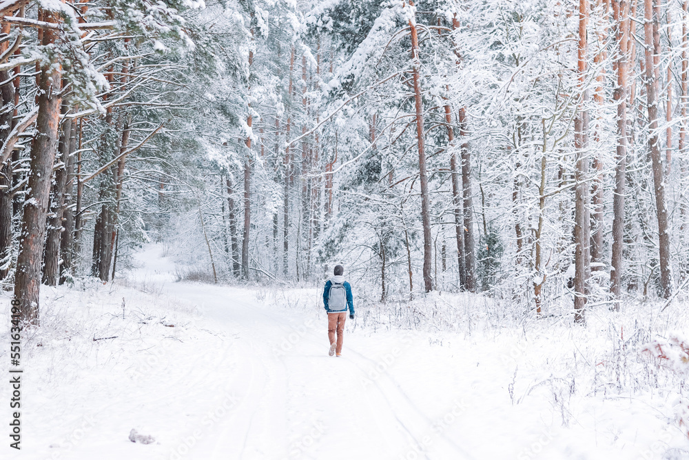 man walking alone in a beautiful snowy forest. Mental health concept