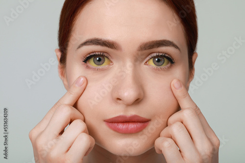 Fotografie Woman with yellow eyes on light grey background