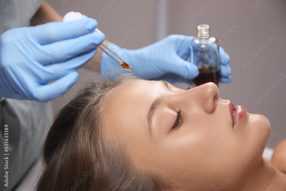 Cosmetologist applying serum on client's face in salon Cosmetologist applying serum on client's face in salon