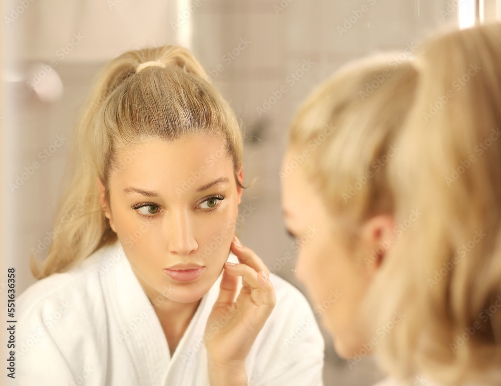 Woman looking in the mirror Applying the cream..Magic anti-aging cream Woman looking in the mirror Applying the cream..Magic anti-aging cream