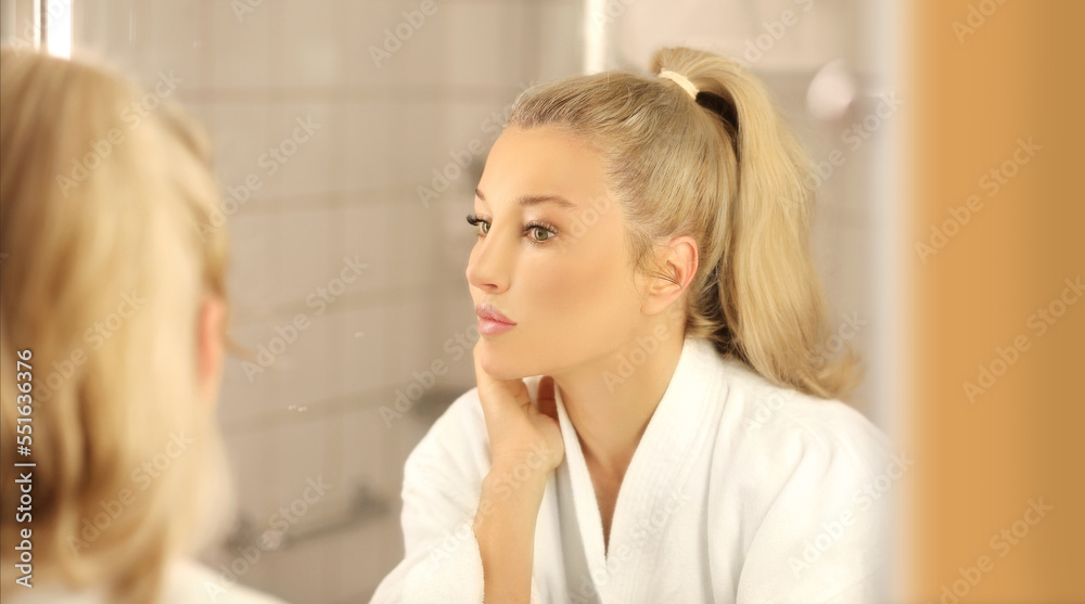 Woman looking in the mirror Applying the cream..Magic anti-aging cream Woman looking in the mirror Applying the cream..Magic anti-aging cream