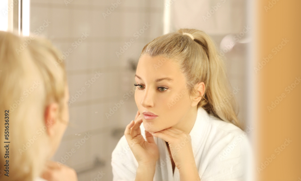 Woman looking in the mirror Applying the cream..Magic anti-aging cream Woman looking in the mirror Applying the cream..Magic anti-aging cream