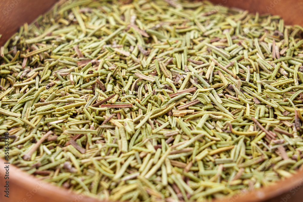 Dry herbal rosemary spice in wooden bowl Dry herbal rosemary spice in wooden bowl