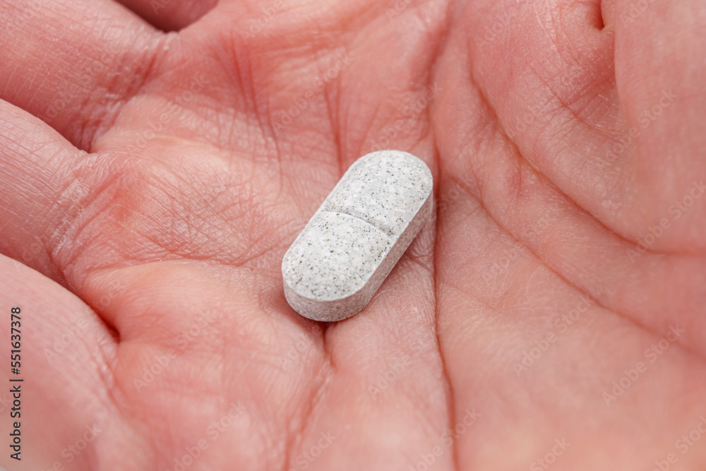 Sedative pills with tryptophan in hand close-up Sedative pills with tryptophan in hand close-up