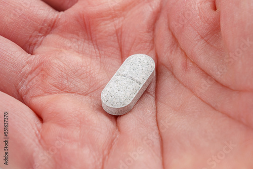 Sedative pills with tryptophan in hand close-up