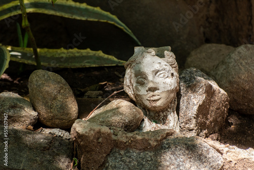 Stone face, between stones, on dark background