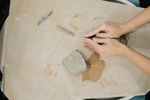 Fotografía Potter wedging and balling clay ready to throw on pottery wheel in ceramic studi