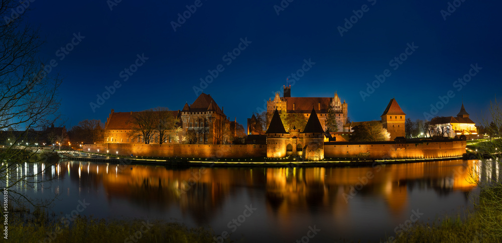 Illuminated Castle of the Teutonic Order in Malbork at night. December 2022 Poland.