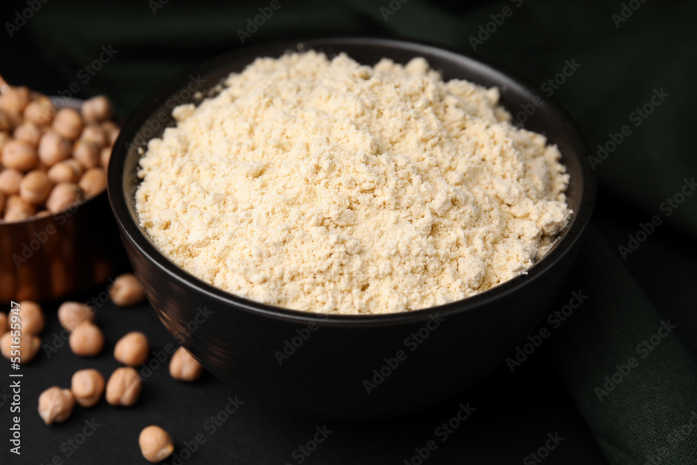 Chickpea flour in bowl and seeds on black table