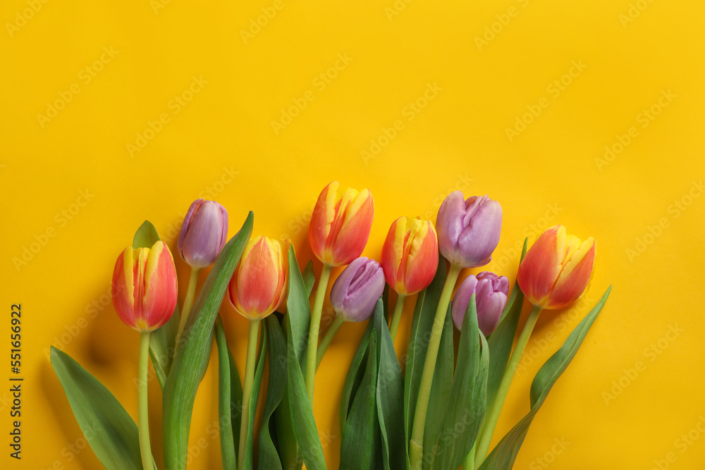 Fototapeta premium Many beautiful tulips on yellow background, flat lay. Space for text