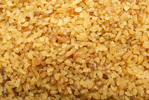 Pile of uncooked bulgur as background, top view