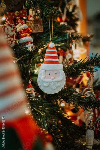 Santa Claus Christmas tree decoration ornament on a branch with lights on