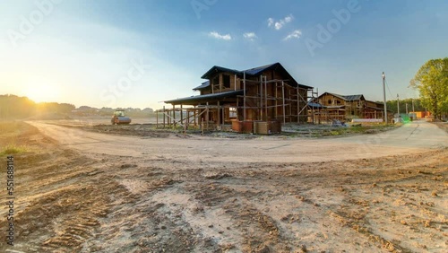 Wooden house cottage under construction timelapse during sunset. New cottage village with blue sky on a background photo