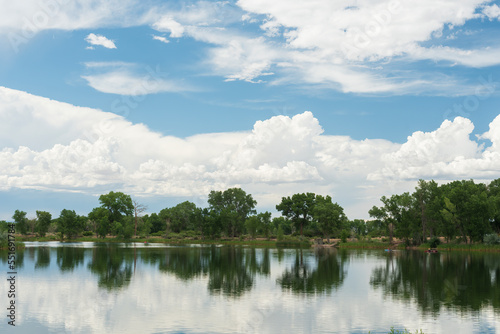 Reflections of clouds and trees in a still lake.