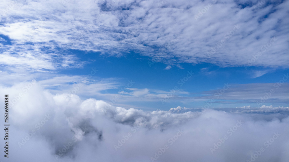 Time lapse of beautiful sky scenery with clouds in the morning. Aerial view of clouds above the blue sky with the sun shining. View of the sea of mist on the mountain top. Sky nature background.