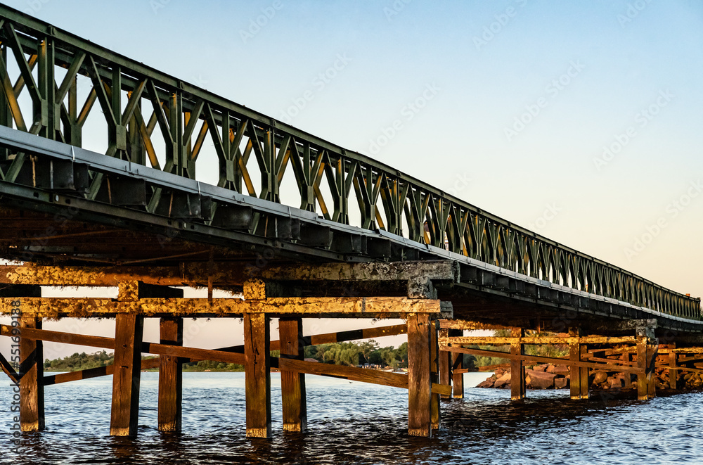 Low angle shot of iron and wooden bridge   located in the town of Colonia Carlos Pellegrini, Corrientes, Argentina during sunset.