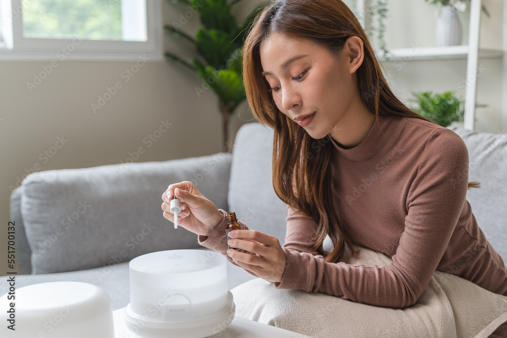 Women drop essential oil into the humidifier to make aromatherapy refreshments atmosphere house for relaxation. Women drop essential oil into the humidifier to make aromatherapy refreshments atmosphere house for relaxation.