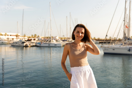 Portrait of a beautiful woman on the background of the blue sea and yachts