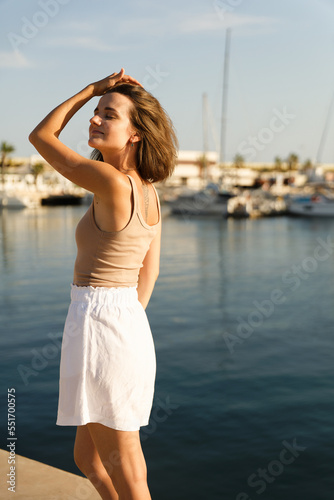 Portrait of a beautiful woman on the background of the blue sea and yachts