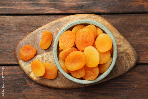 Bowl of tasty apricots on wooden table, top view. Dried fruits photo