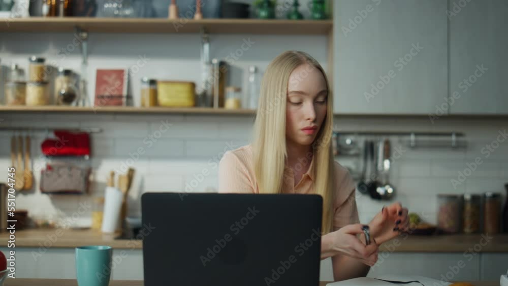 Woman watching educational webinar on laptop sitting kitchen close up. Woman watching educational webinar on laptop sitting kitchen close up.