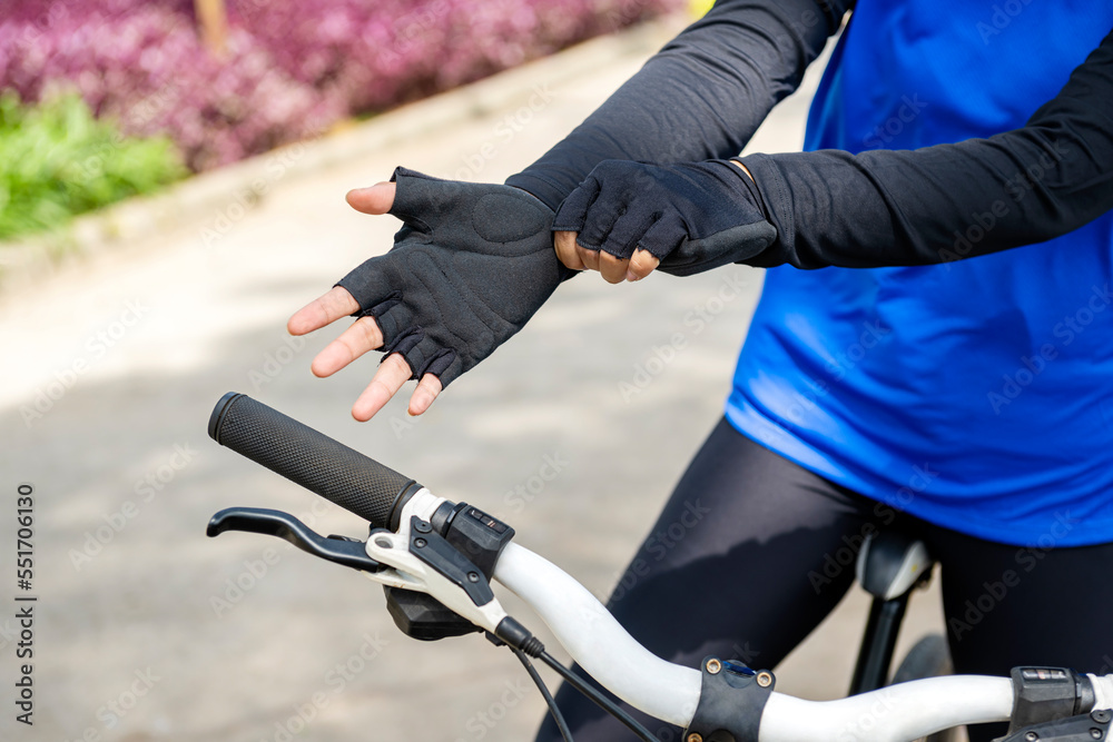 Woman wearing a gloves preparing for the bike ride Woman wearing a gloves preparing for the bike ride