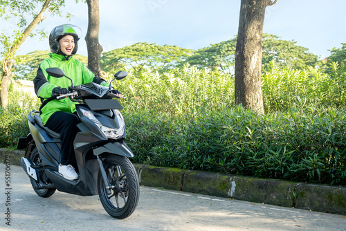 Asian woman works as a motorcycle taxi driver