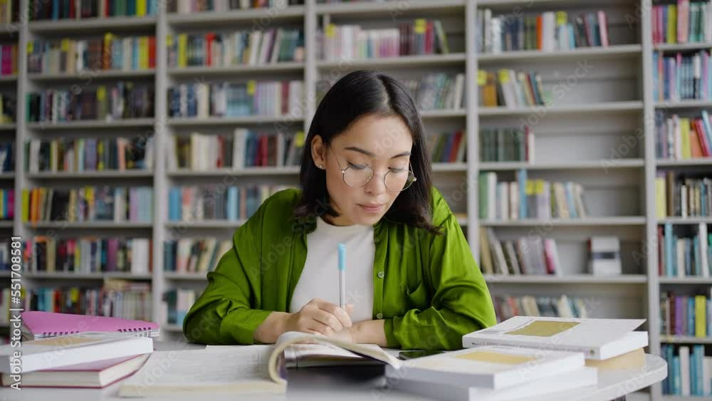 Young Asian woman communicates in social networks in library Young Asian woman communicates in social networks in library