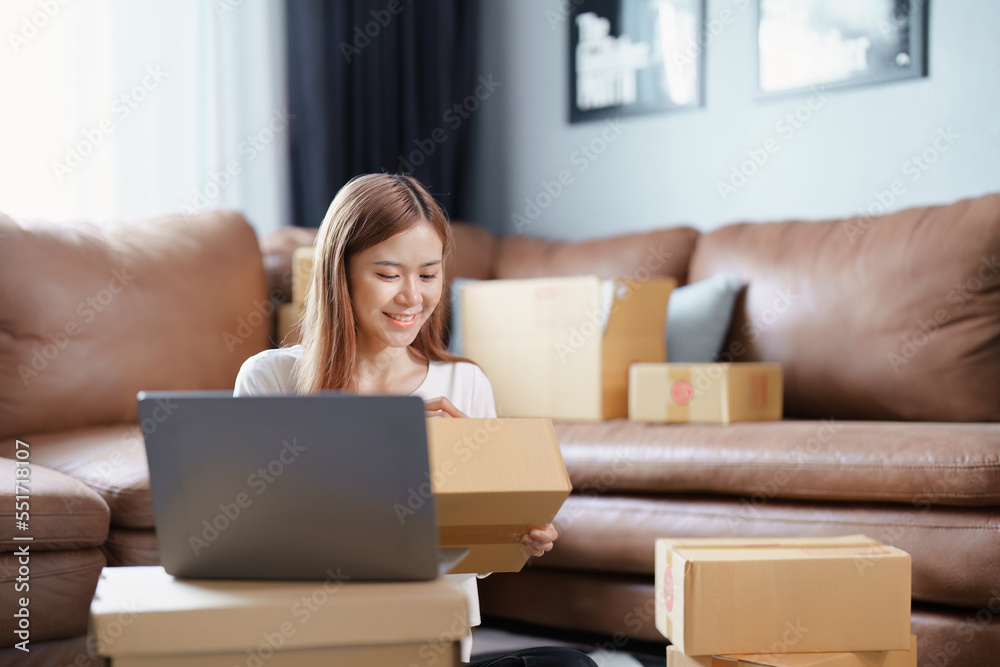 Starting small business entrepreneur of independent Asian female online seller packing products to send to customers and SME delivery concept Starting small business entrepreneur of independent Asian female online seller packing products to send to customers and SME delivery concept