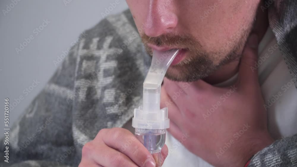 Man does inhalation at home during an illness pneumonia, infection with coronavirus covid 19. Medical inhaler, nebulizer, nebular. Asthma breathing treatment. Bronchitis, asthmatic health equipment. Man does inhalation at home during an illness pneumonia, infection with coronavirus covid 19. Medical inhaler, nebulizer, nebular. Asthma breathing treatment. Bronchitis, asthmatic health equipment.